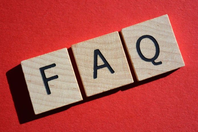 FAQ acronym for Frequently Asked Questions in 3D wooden alphabet letters on a bright red background